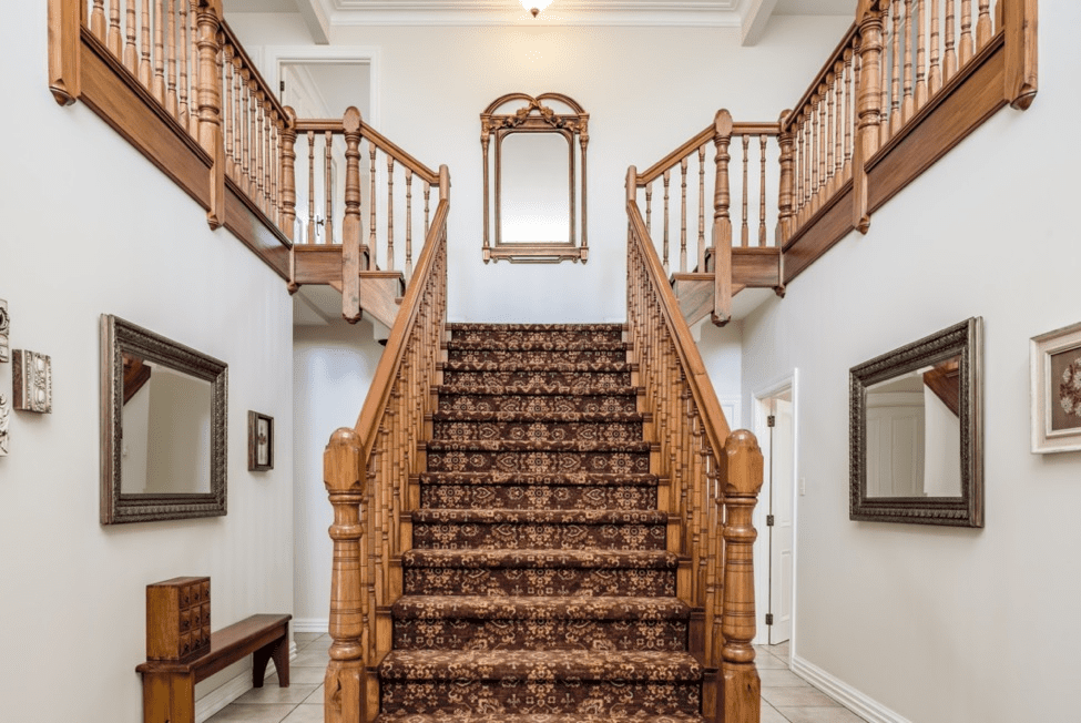 wooden bifurcated staircase with carpet