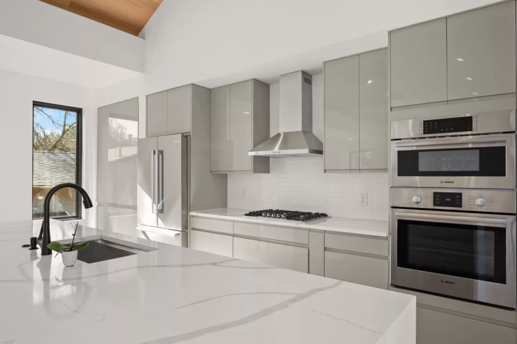 Newly renovated kitchen in Austin, Texas. White marble countertops, ergonomic and upgraded kitchen appliances, and minimalistic cabinets.