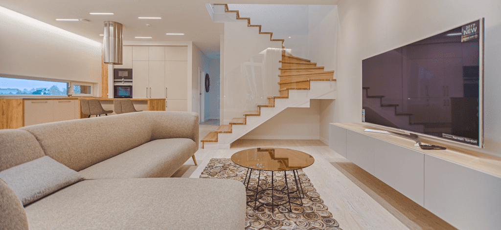A luxury living room with light wood accents and a custom staircase.