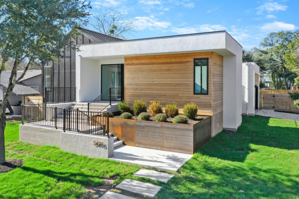 exterior of a luxury home in Austin, TX, with a horizontal wood facade and wrought iron planter 