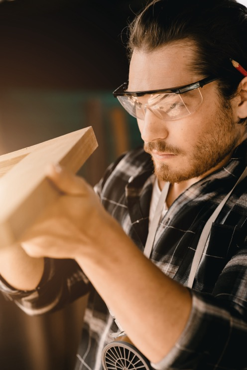 a carpenter checks a joint in a frame for a commercial construction company