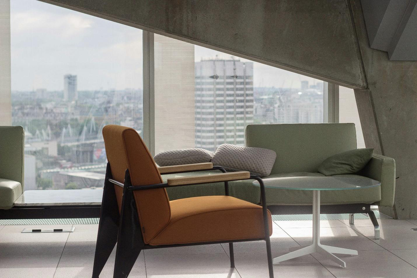 A couch and an armchair inside a well-lit office