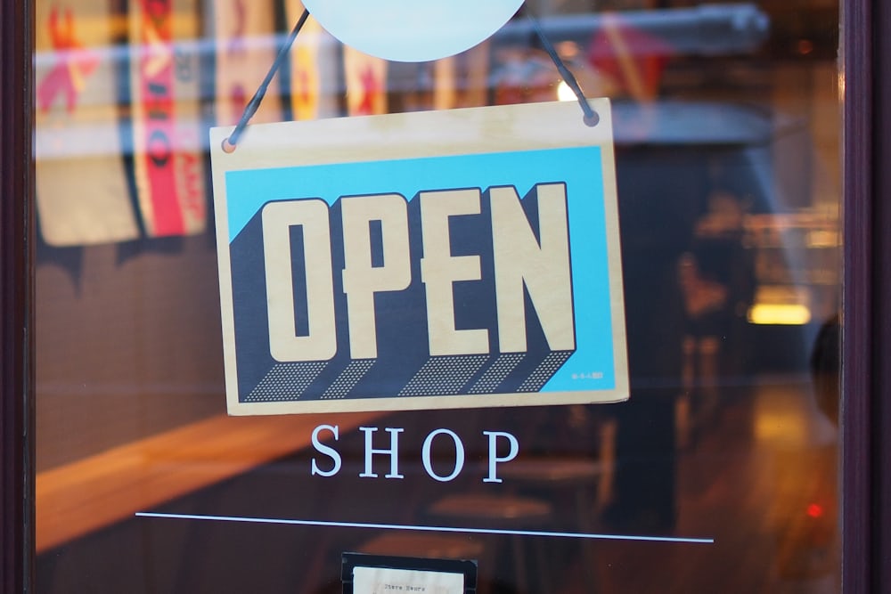 an open sign hangs in the window of a retail store