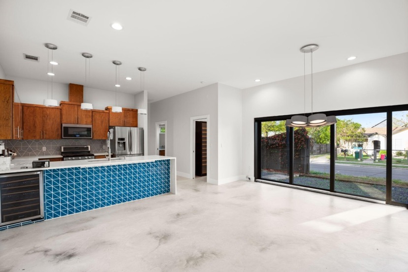 A kitchen design and layout with an open floor plan, kitchen island, and appliances.