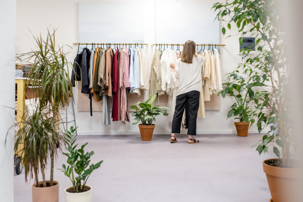 A person picking clothes from the rack in a retail store