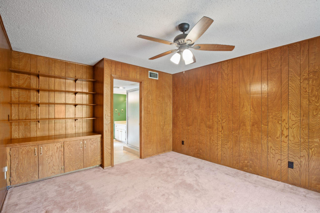 The interior of a house with wooden shelves and a fan designed by custom home builders