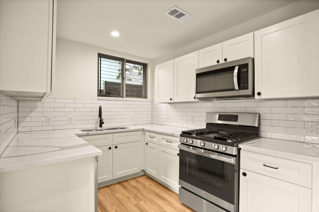 Kitchen renovation with appliances, sink, window, and cabinets