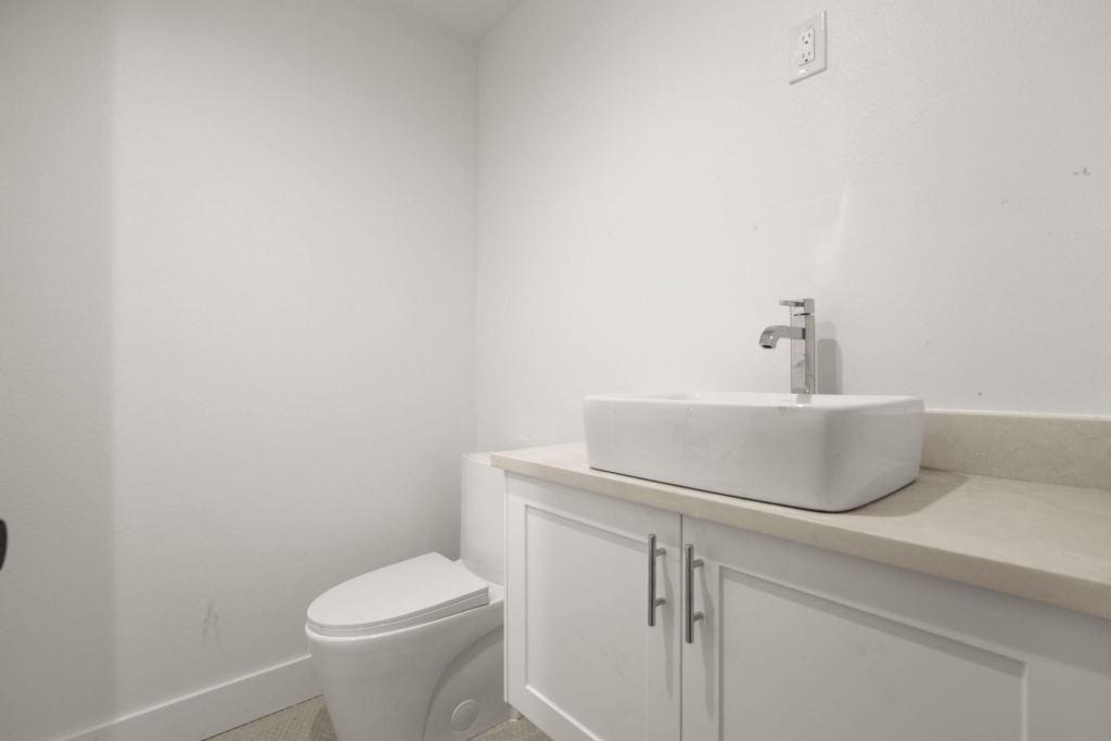 A remodeled bathroom with sink, cabinets, and a toilet