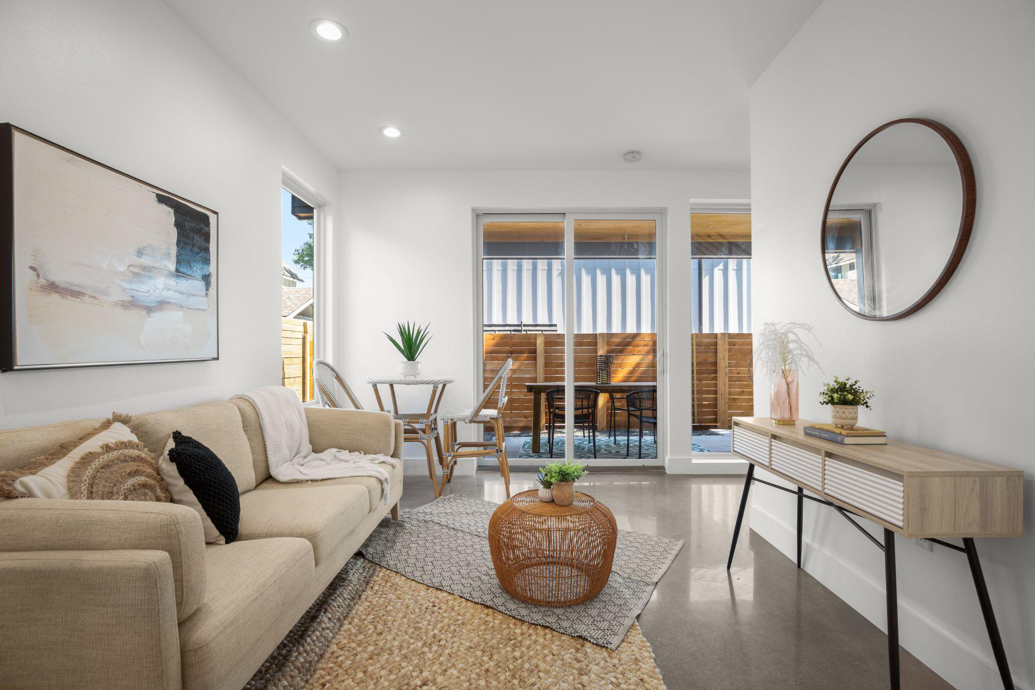 A furnished living room home addition with a couch, window, and center table, and chairs and plants