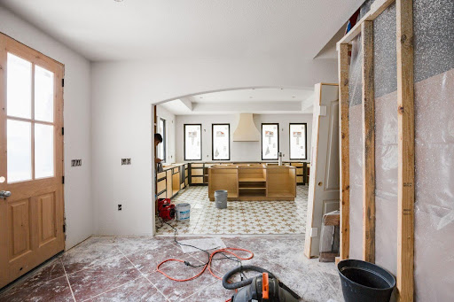 An ongoing room addition project with wooden studs and half-finished cabinets in a room, alongside tools 