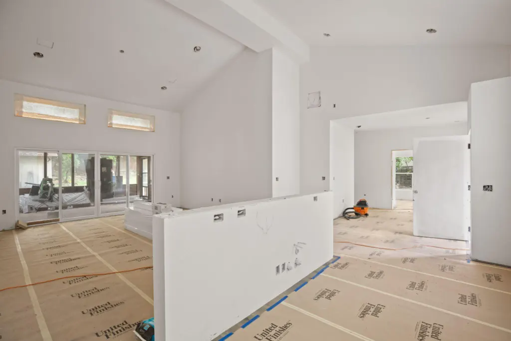 A house being remodeled with white walls and carton material on the floor