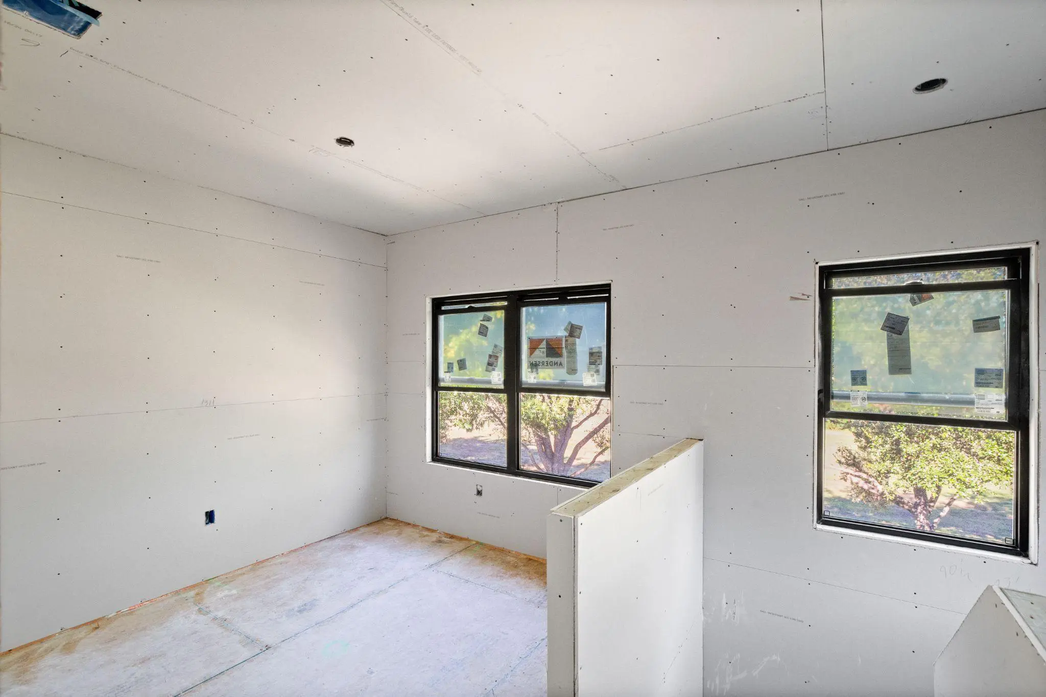 A room with white walls and windows being remodeled