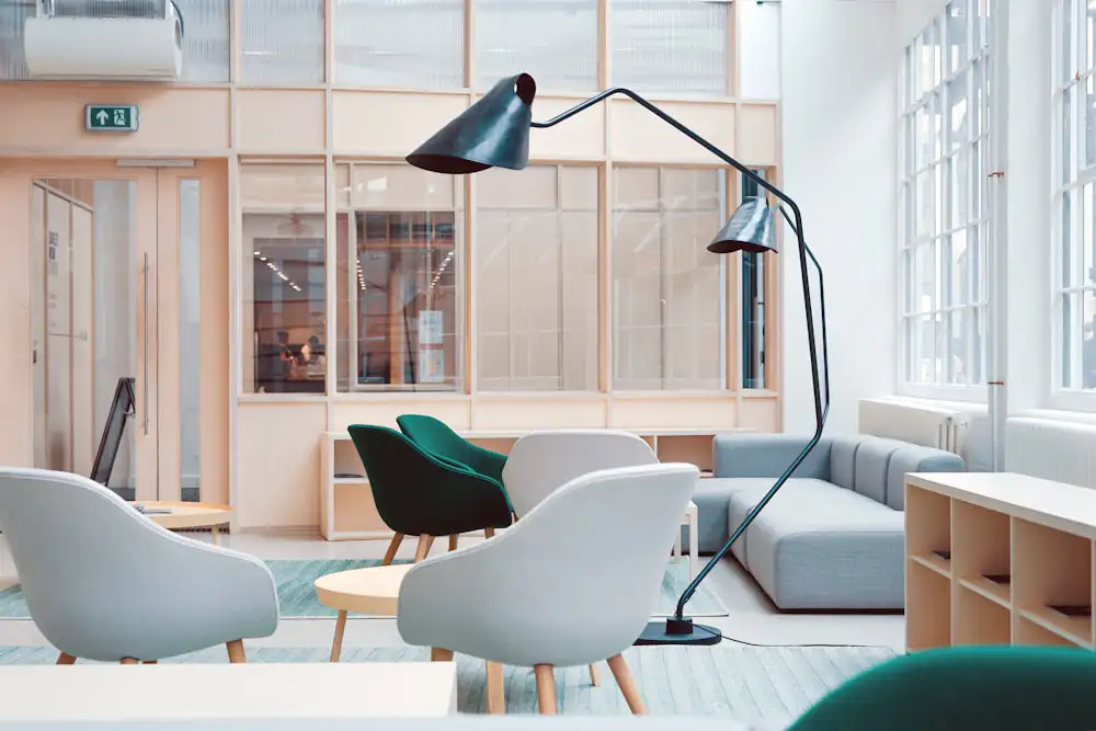 a teal and light wood office space with a casual meeting area