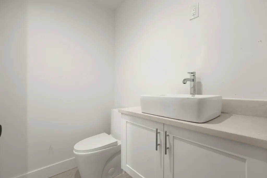 A remodeled bathroom with sink, cabinets, and a toilet