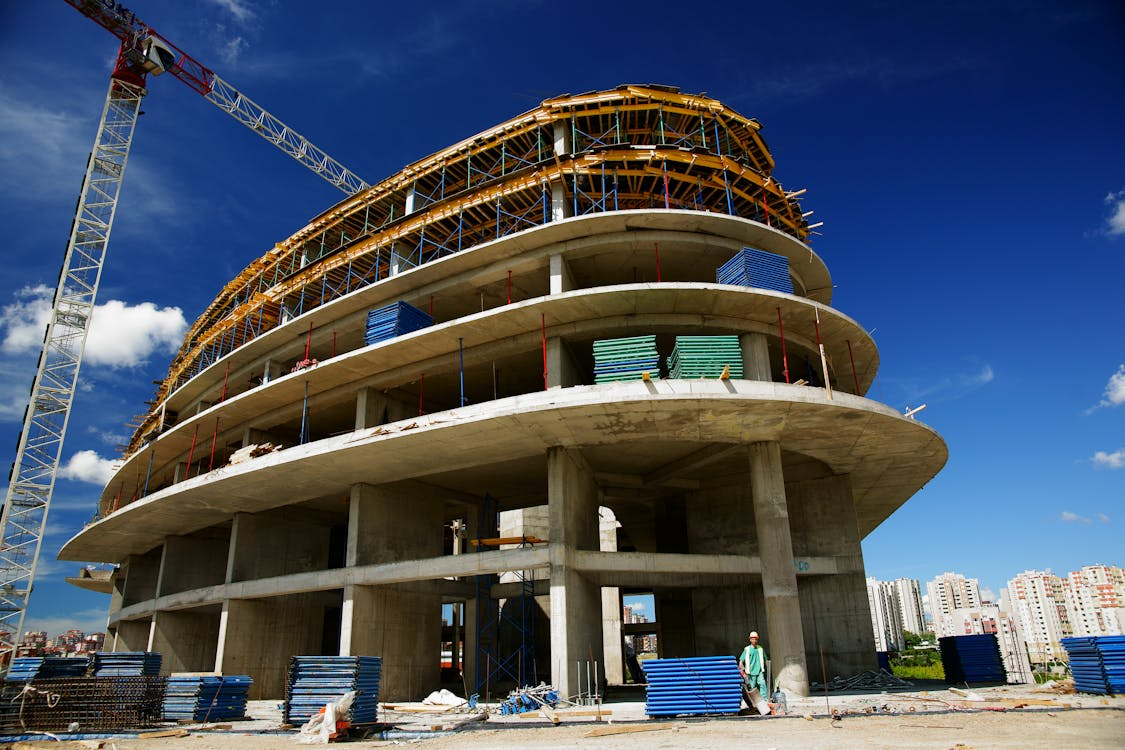 An under-construction gray building with sky in the background