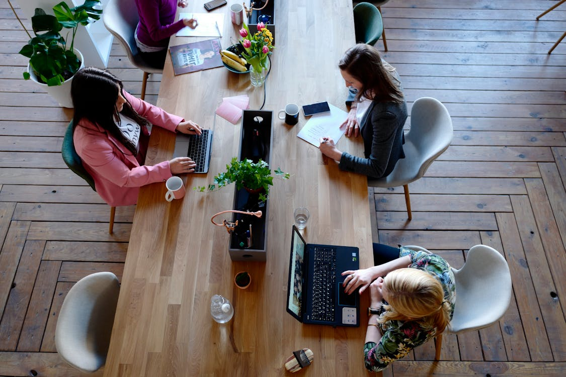 A group of people working on their laptops on a table