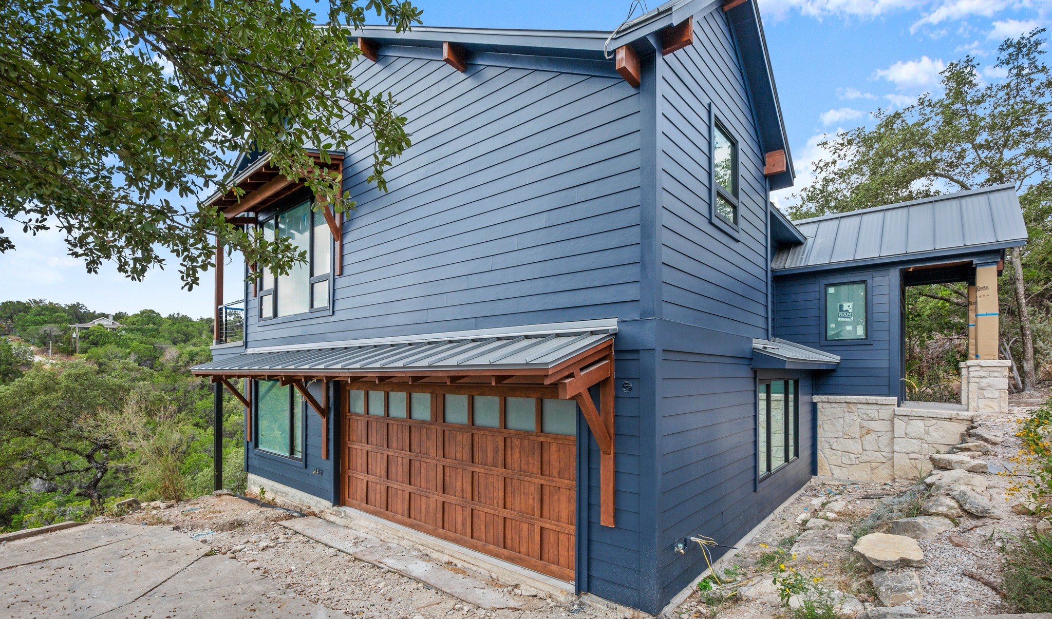 A ranch-style home with blue siding and a limestone porch