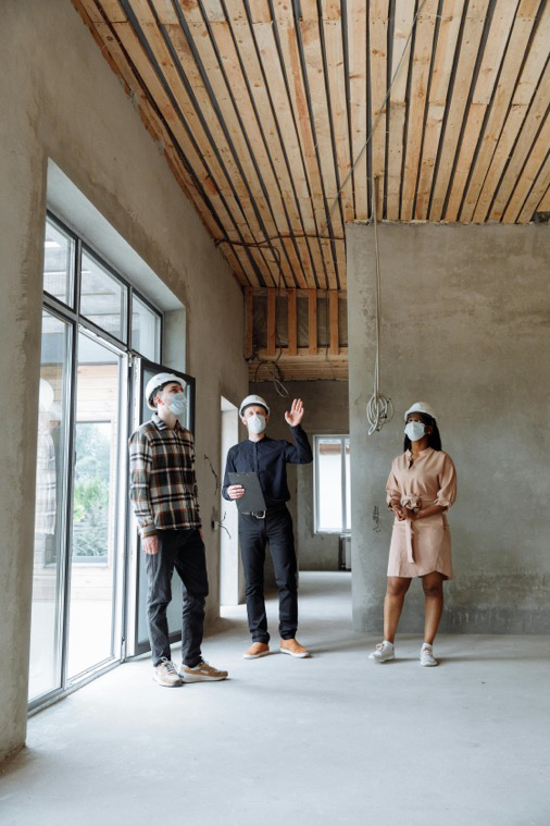 Two men and a woman involved in a commercial remodel project touring the work